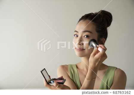 Woman doing make-up 68763162