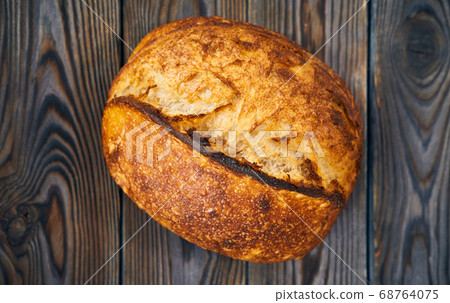 Homemade tartine bread on dark wooden table Homemade tartine bread on dark wooden table 68764075