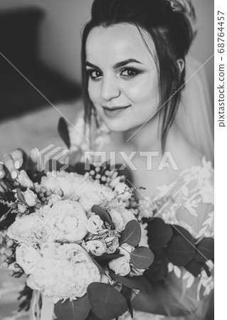 Gorgeous bride in robe posing and preparing for the wedding ceremony face in a room Gorgeous bride in robe posing and preparing for the wedding ceremony face in a room 68764457