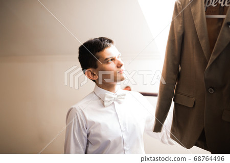 Beautiful man, groom posing and preparing for wedding Beautiful man, groom posing and preparing for wedding 68764496