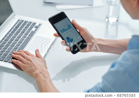 Hands of young contemporary broker analyzing financial graphs and diagrams Hands of young contemporary broker analyzing financial graphs and diagrams 68765585