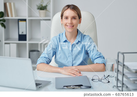 Young attractive businesswoman with blond hair and toothy smile looking at you Young attractive businesswoman with blond hair and toothy smile looking at you 68765613