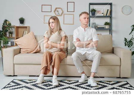 Young married couple with crossed arms and offended facial expression Young married couple with crossed arms and offended facial expression 68765755