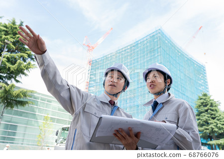 Businessman looking at drawings on construction site 68766076