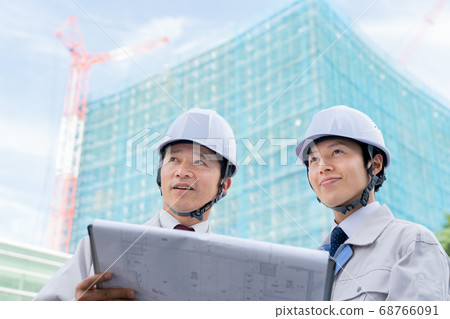 Businessman looking at drawings on construction site Businessman looking at drawings on construction site 68766091