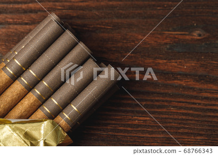 Pack of cigarettes close up on wooden background Pack of cigarettes close up on wooden background 68766343