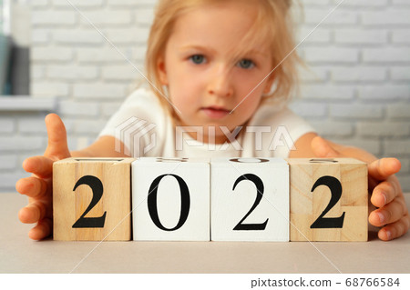 Toddler girl holding 2021 wooden cubes. Conceot of New Year 2021 Toddler girl holding 2021 wooden cubes. Conceot of New Year 2021 68766584