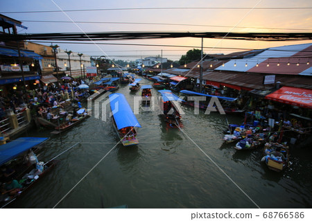 Thai people is selling the food to tourists in Amphawa floating market with sunset Thai people is selling the food to tourists in Amphawa floating market with sunset 68766586