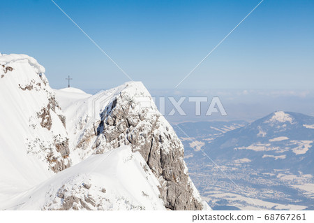 Untersberg Summit. The view across the summit of Untersberg mountain in Austria looking towards a cross. The mountain straddles the border between Germany and Austria. 68767261