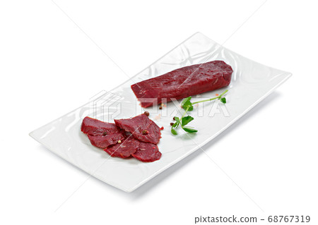 Thin pieces of sliced sausage on white plate isolated on white Thin pieces of sliced sausage on white plate isolated on white 68767319