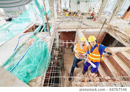 Builder and contractor on construction site Builder and contractor on construction site 68767546