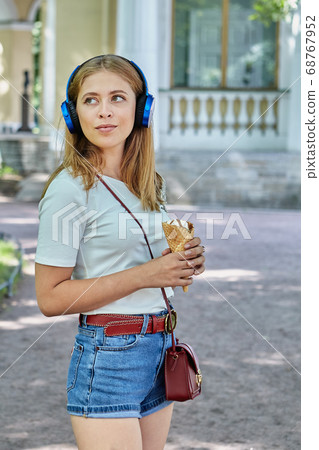 Attractive white woman is eating ice cream. Attractive white woman is eating ice cream. 68767952