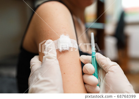 Girl with plaster on the shoulder from injection. Girl with plaster on the shoulder from injection. 68768399