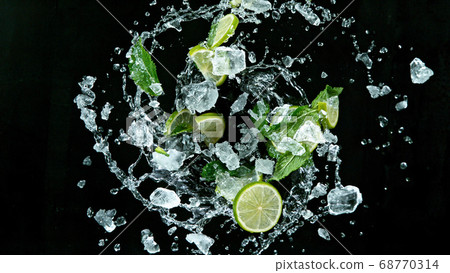 Fresh ripe limes flying on a black background. 68770314