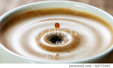 Sugar cube falling into a cup of coffee Sugar cube falling into a cup of coffee 68771005