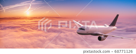 Commercial airplane jetliner flying above dramatic 68771126