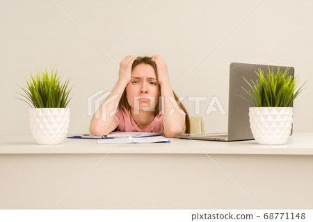Tired overworked young intern woman working with a Tired overworked young intern woman working with a 68771148