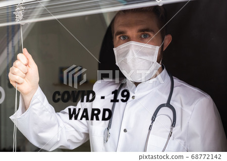 Medicine and health care concept. Man doctor in hospital. Doctor wearing protective mask checking and take care infected people from covid-19. 68772142