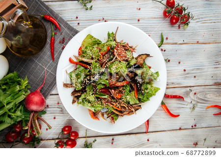 Warm salad with beef vegetables on wooden table Warm salad with beef vegetables on wooden table 68772899