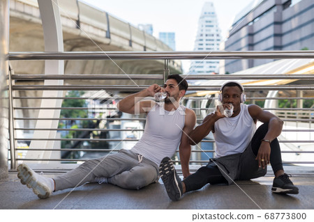 American friends sit and drink water after 68773800