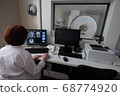 Professional Scientists Work in the Brain Research Laboratory. Neurologists Neuroscientists Surrounded by Monitors Showing CT, MRI Scans Having Discussions and Working on Personal Computers. 68774920