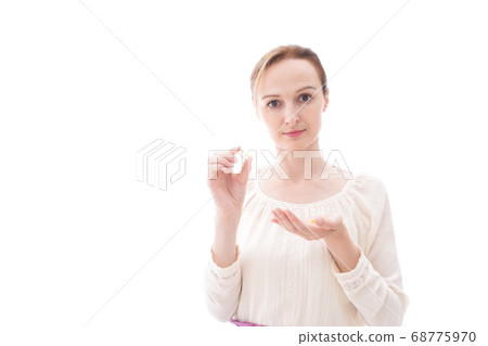 Smiling young woman drinking supplements 68775970