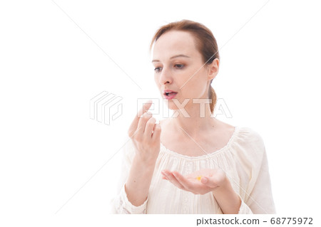 Smiling young woman drinking supplements 68775972
