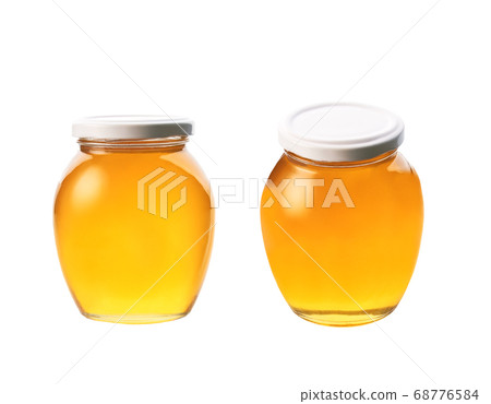 glass jar of honey isolated on white background. glass jar of honey isolated on white background. 68776584