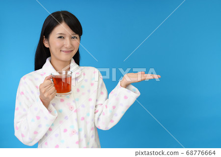 A woman drinking tea A woman drinking tea 68776664