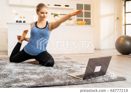 White caucasian woman do yoga while working at 68777219