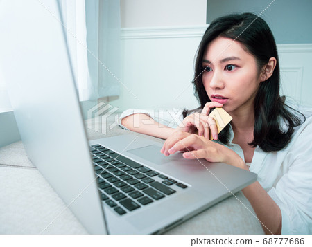 Young woman shopping online with credit card and 68777686