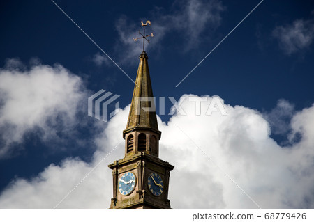 Church Steeple and Clock Against a Blue Cloudy Sky 68779426