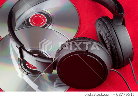 CDs and Headphones on a Red Background 68779515
