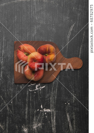 Red peaches on a wooden cutting board 68782975