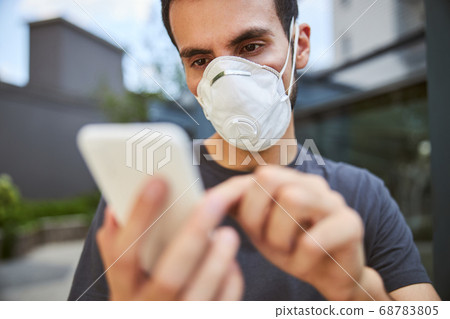 Serious young man using his cellular phone Serious young man using his cellular phone 68783805