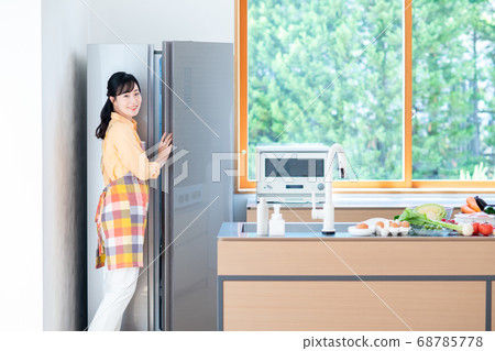 Middle-aged housewife opening the refrigerator 68785778