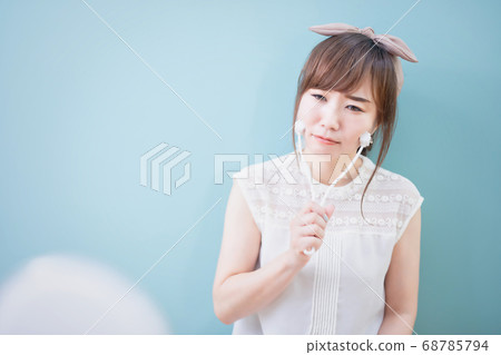 A woman using beautiful face roller 68785794