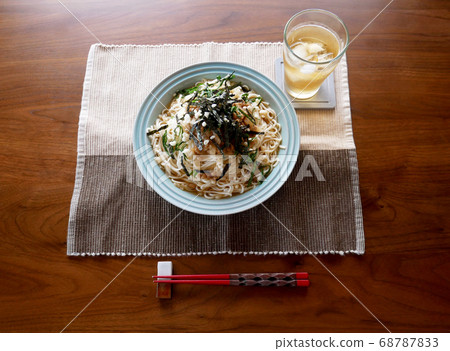 Cold grated natto udon and barley tea placed on the table, perfect for summer 68787833