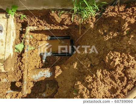 Construction in which the underground water supply pipe on the house premises that had leaked water was replaced with a new black pipe 68789060