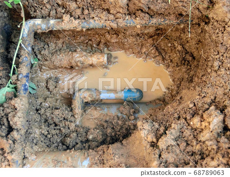 A pipe with a temporary cap attached by cutting the damaged part of the underground water pipe on the house premises that had leaked water. 68789063