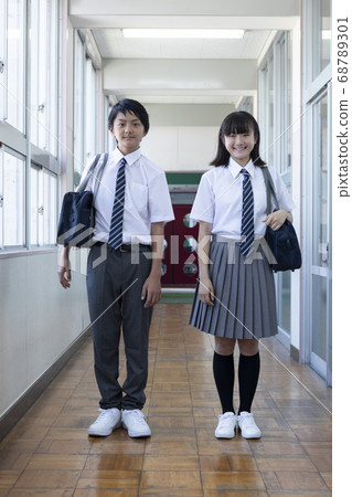 Junior high school students standing side by side in the corridor 68789301