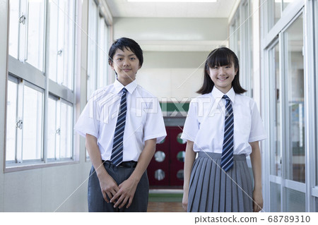 Junior high school students standing side by side in the corridor 68789310