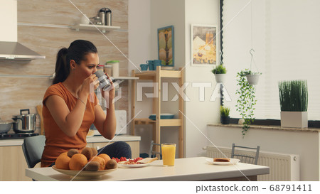 Taking a sip of coffee Taking a sip of coffee 68791411