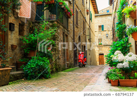 Typical Italian street with colorful flowers and scooter, Pienza, Tuscany 68794137