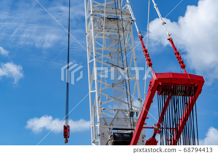 Crawler crane against blue sky and white clouds. 68794413