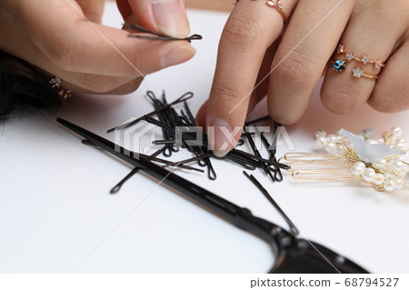 An Asian woman is touching a hairpin for hair care. An Asian woman is touching a hairpin for hair care. 68794527