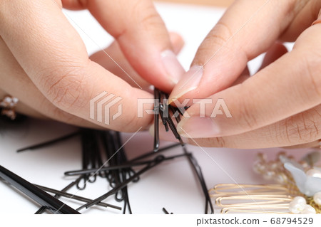 An Asian woman is touching a hairpin for hair care. An Asian woman is touching a hairpin for hair care. 68794529