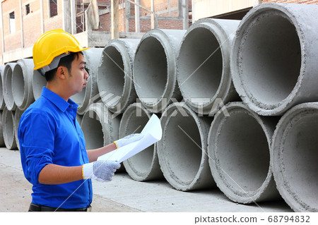 the worker is checking the stock of cement drain in construction site the worker is checking the stock of cement drain in construction site 68794832