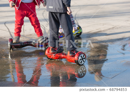 happy children ride on an electric giboard in the happy children ride on an electric giboard in the 68794853