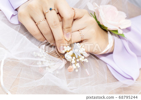 The bride is touching her hairpin to care for her hair 68795244